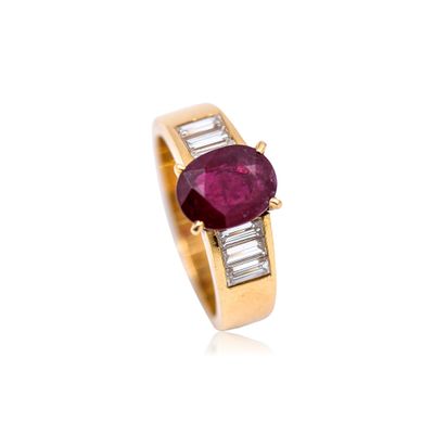 a close up of a ring with a ruby stone and baguets