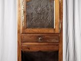 an old wooden cabinet with a door and a drawer on top of it