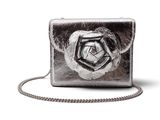 Le porte-monnaie en argent est orné d'une rose sur le devant et d'une chaîne qui l'entoure.