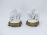 pair of white marble figurines of a boy and a girl on a pedestal