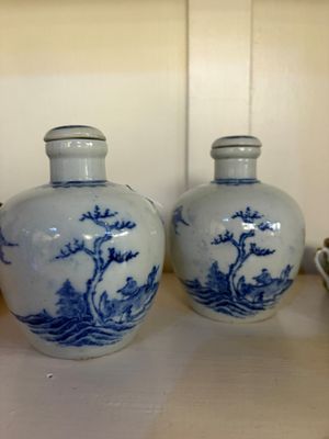 two blue and white vases sitting on a shelf