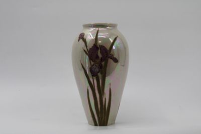 un vase orné d'une fleur violette sur un fond blanc