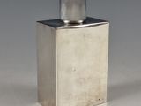 an image of a silver bottle with a metal cap sitting on a white surface