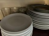 a stack of plates and glasses on a table
