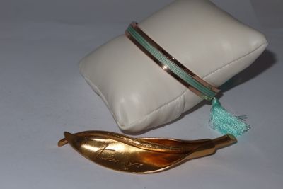 un oreiller blanc et une banane dorée posés sur une table