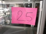 a pink sign that says 25 on it in the window of a store