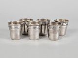 un ensemble de six tasses en argent posées sur un plateau blanc