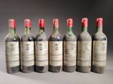 six bouteilles de vin sont alignées sur une table