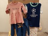 une pile de vêtements pour bébés posée sur une palette devant un carton