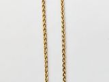 the gold chain is attached to a necklace on a white surface