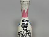 a small white and pink bowling pin with a picture of a man on it