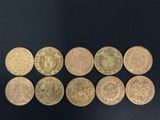 a group of six gold coins sitting on top of a black surface