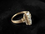 a close up of a gold and diamond ring on a black cloth