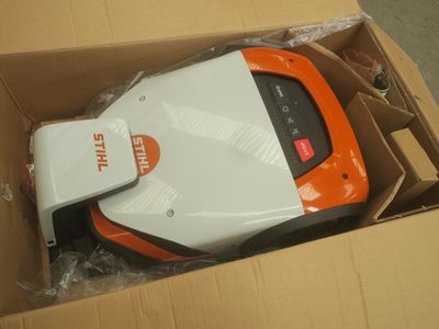 un aspirateur orange et blanc dans un carton