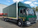 un camion vert garé devant un immeuble