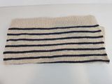 a close up of a white and black striped sweater on a white surface