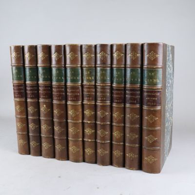 six vieux livres alignés sur une surface blanche