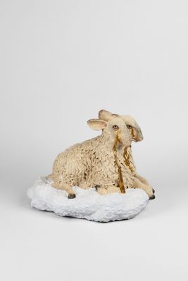 deux figurines de moutons posées sur un sol recouvert de neige
