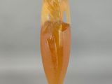 yellow and orange sculpture of a flower on a wooden base