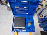 une boîte à outils bleue contenant une petite balance à l'intérieur