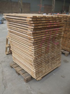 plusieurs piles de bois empilées les unes sur les autres dans un entrepôt