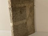 un vieux livre posé sur une table, d'où dépasse un bout de papier