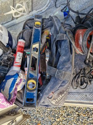 a pile of tools sitting on the ground next to a wall