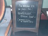 une ardoise posée sur une chaise, devant une autre chaise