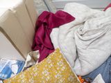 a pile of clothes on the floor next to a bed