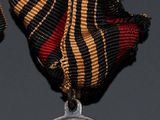two medals on a black surface with a red and yellow ribbon