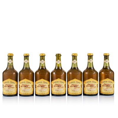 six bottles of beer lined up in a row on a white surface