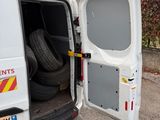 a white van with its door open and a tire in the back