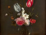 flowers in a glass vase on a table with a dark background