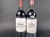 two bottles of red wine sitting next to each other on a table