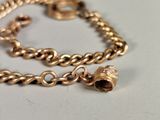 a gold chain bracelet with a bell on it