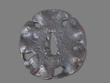a metal object with holes in it on a gray surface