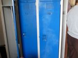 a woman standing next to a blue locker in a room