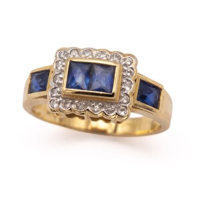 a close up of a blue sapphire and diamond ring on a white background