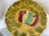 a plate with a bird on it next to a bowl with berries on it