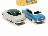 two toy cars sitting next to each other in front of a box
