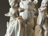 a white cake with figurines of people on it