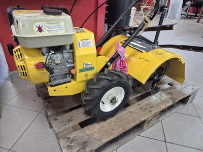 a small yellow machine that is sitting on a pallet
