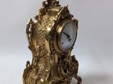 an image of a gold clock sitting on top of a white table