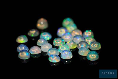 a close up of a pile of white oplite beads on a black surface