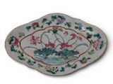 a plate with flowers and leaves on it on a white surface