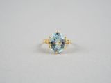 une bague en topaze bleue avec un anneau en or et une pierre de topaze bleue