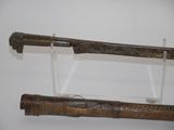 two old swords on display on a white wall