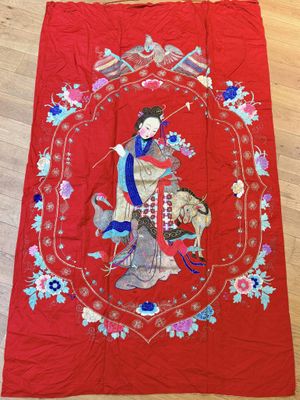 a red cloth with a woman and a dog on it