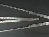 Deux vieux outils en métal sont posés sur une surface noire.