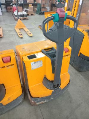 two yellow forklifts in a warehouse with pallets in the background